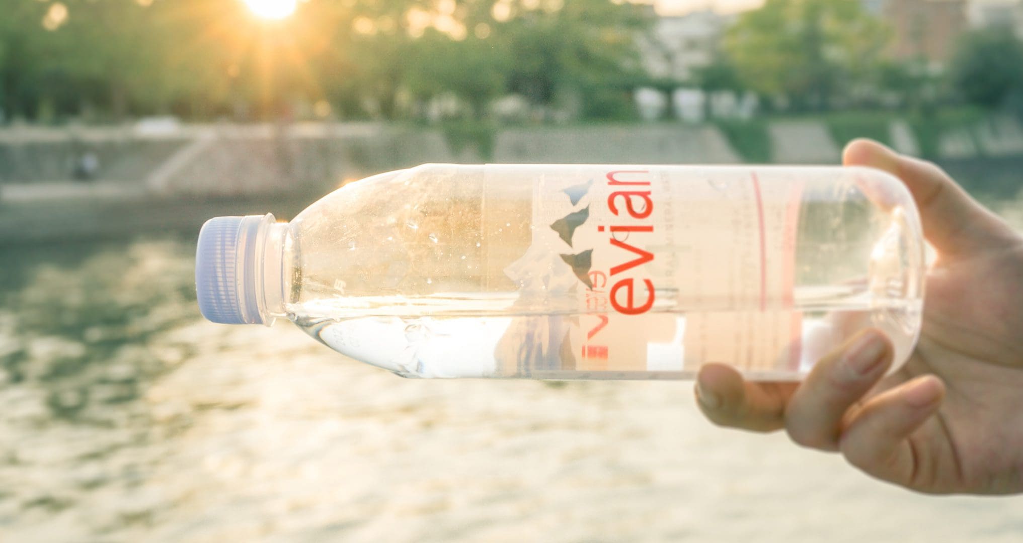 evian bottled water in someones hand