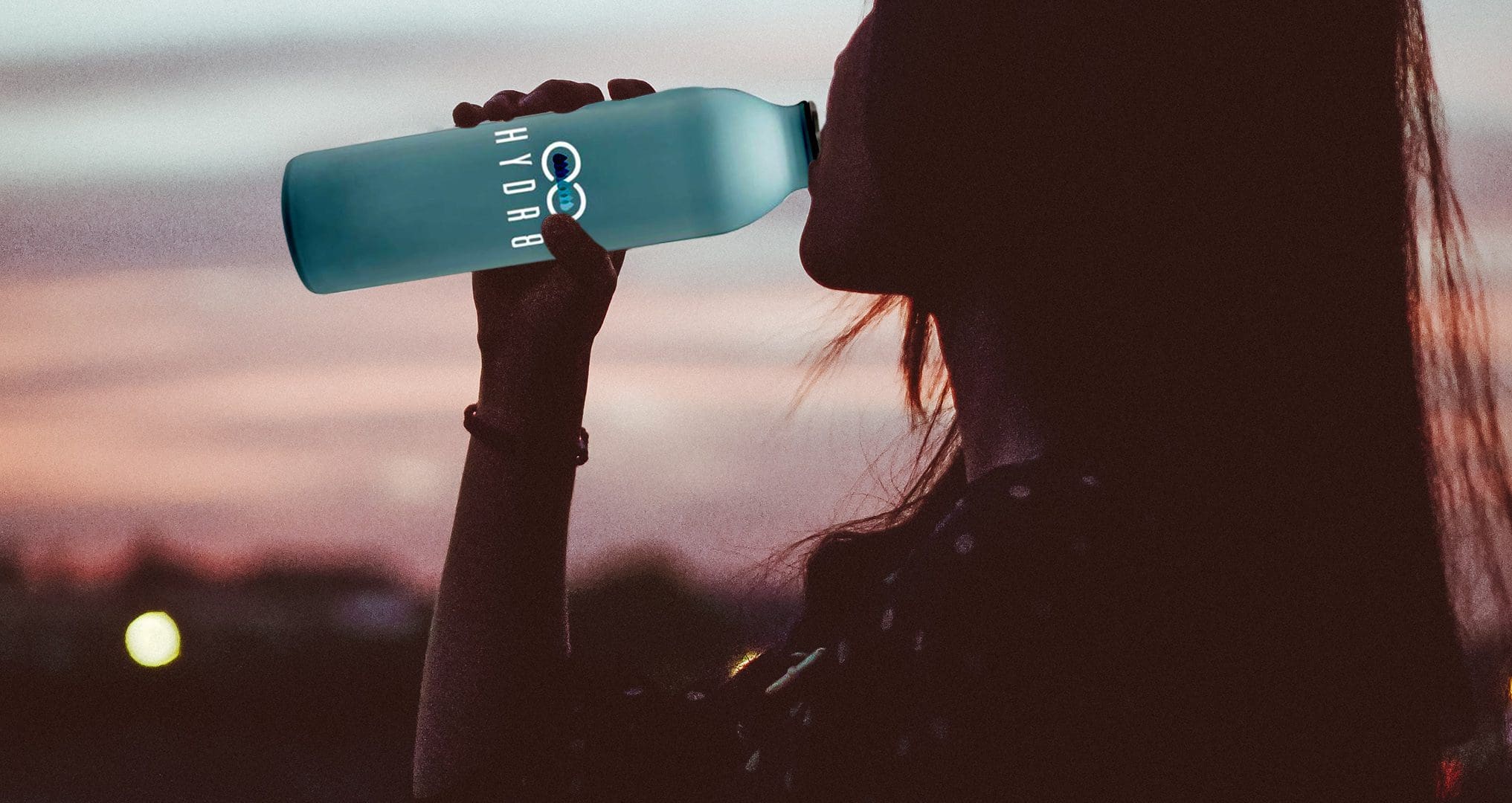 woman drinking from Hyd8 water bottle
